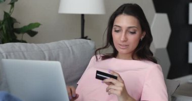 Bilgisayardan internet hizmetleri için kredi kartı kullanan kadın