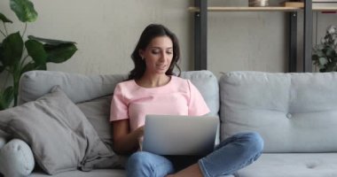 Hintli bir kadın evinde oturup dizüstü bilgisayar kullanıyor.