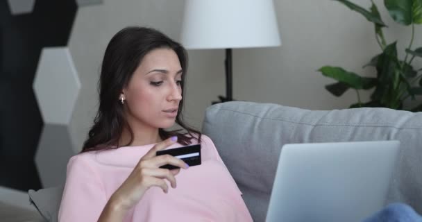 Mujer utilizar la tarjeta y el ordenador portátil que tiene problemas de pago se siente perplejo — Vídeos de Stock