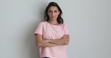Gri arka planda kollarını kavuşturmuş neşeli Hintli kadın pozu
