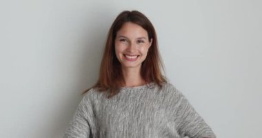 Kadın ellerini göğsüne koyar, kalp şeklinde parmaklar yapar.