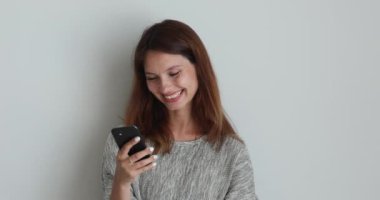 Gülümseyen kadın internetten cep telefonu izleyip