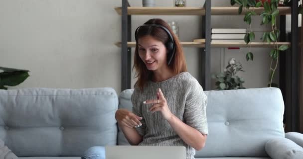 Γυναίκα φορούν ακουστικά κοιτάζοντας οθόνη laptop εργασίας από videoconference — Αρχείο Βίντεο