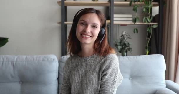 Vrouw dragen headset glimlach kijk naar camera praten door videocall — Stockvideo