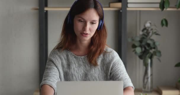 Mujer seria en auriculares hablar con el ordenador portátil y la aplicación de videoconferencia — Vídeos de Stock