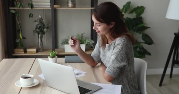 Женщина, сидящая за столом с помощью интернет-письма, наслаждается процессом обучения — стоковое видео