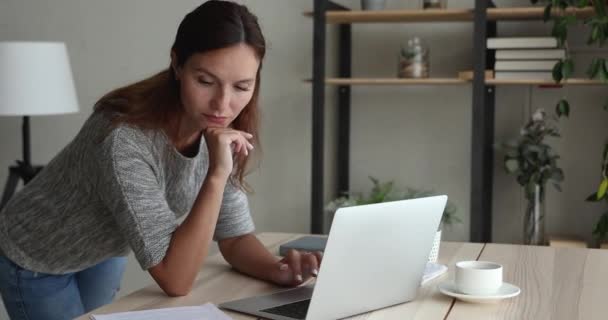 Женщина, работающая на ноутбуке, анализирует отчетность, проводит исследования — стоковое видео