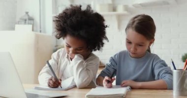 Ciddi küçük melez çocuklar el yazısı ödevi, uzaktan öğrenme.