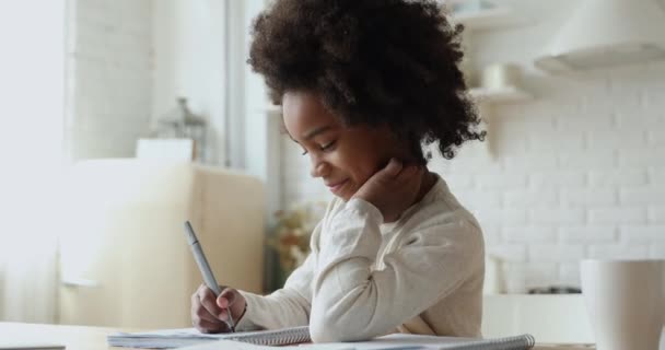 Gericht weinig Afrikaanse etniciteit meisje betrokken bij het doen van huiswerk. — Stockvideo