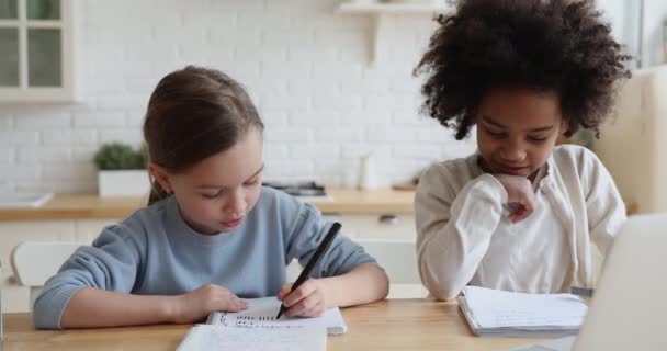 Gelukkig schattig kleine multiraciale vrienden meisjes doen huiswerk binnen. — Stockvideo