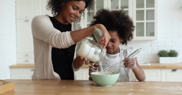 Mutlu Afrikalı Amerikalı genç anne kızına krep yapmayı öğretiyor.. — Stok video