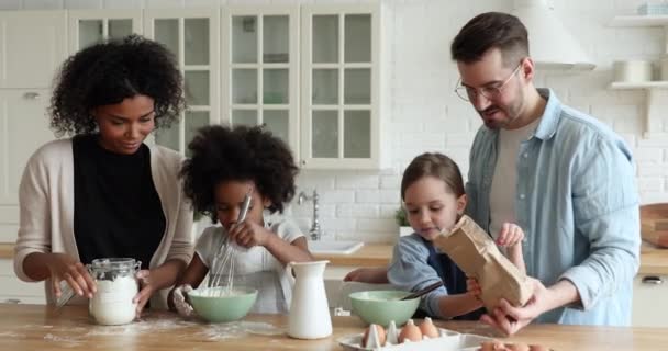 Glückliche multiethnische Eltern helfen kleinen Kindern beim Teigmachen. — Stockvideo