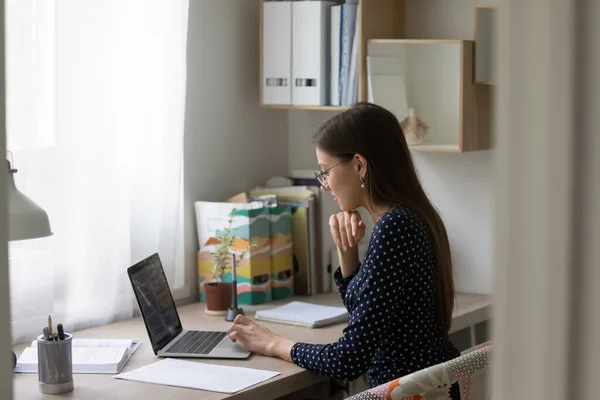 Ung flicka sitter vid skrivbordet studie på bärbar dator — Stockfoto