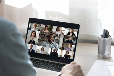 Erkek çalışanın arka planda iş arkadaşlarıyla webcam konferansı var
