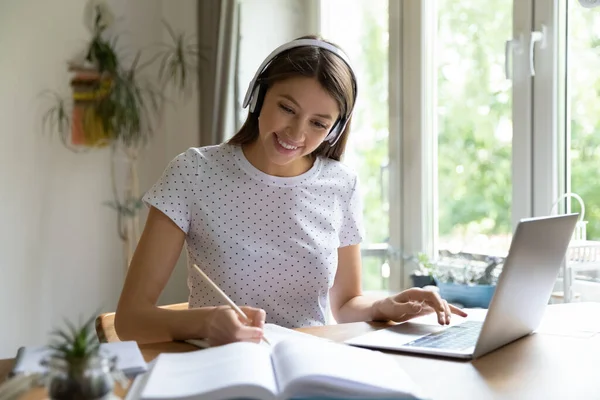 Smiling girl in headphones study online using laptop — Stock Photo, Image
