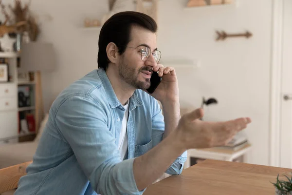 Heureux jeune homme parler sur téléphone portable à la maison — Photo