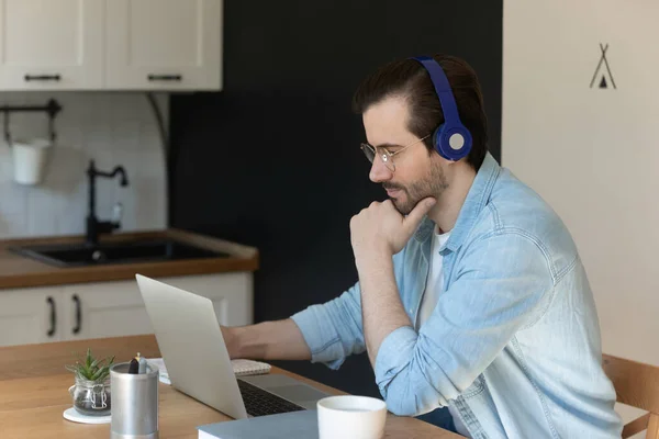 Millennial muž ve sluchátkách sledovat webinář na notebooku — Stock fotografie