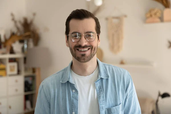 Profile picture of smiling millennial man in glasses posing