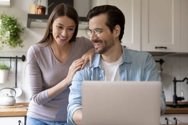 Smiling young couple have fun using laptop — Stock Photo, Image