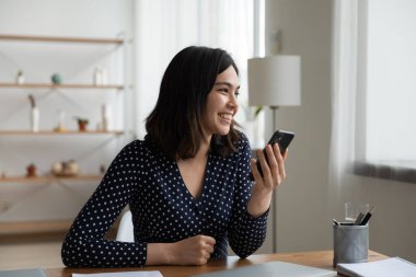 Gülümseyen Asyalı kız cep telefonu kullanıyor rüya görüyor ya da düşünüyor