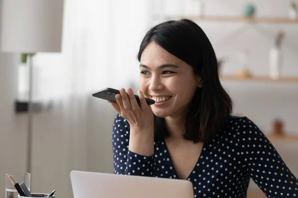 Sonriente chica asiática activar asistente de voz virtual en el teléfono celular — Foto de Stock
