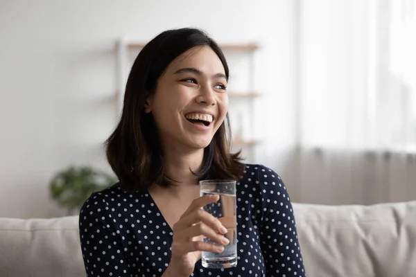 Smiling Asian girl drink clean mineral water
