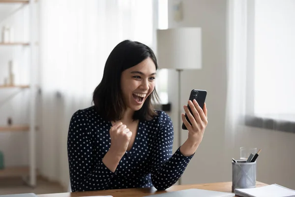 Emocionado chica vietnamita triunfo con texto en el teléfono celular — Foto de Stock