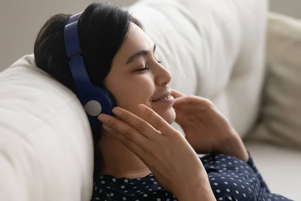 Gelukkig aziatische vrouw in hoofdtelefoon luisteren naar muziek — Stockfoto