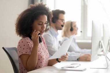 Kulaklık kağıdı okuyarak karışık ırk çağrı merkezi operatörü