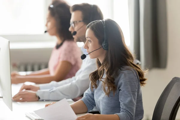 Call center agent in headset consulting client, working with documents