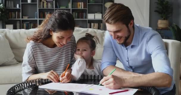 Glada föräldrar ritar bilder med liten dotter. — Stockvideo