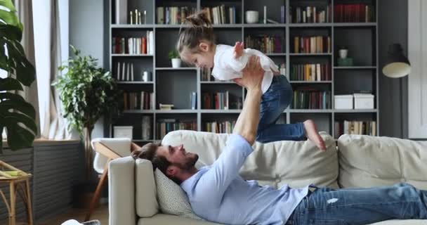 Gelukkig jong vader vasthouden aan gestrekte armen schattig dochter. — Stockvideo