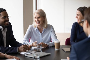 Ofiste grup brifinginde gülen çok ırklı, neşeli iş arkadaşları.
