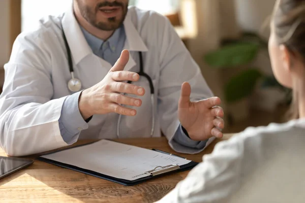Confident young male doctor examining ill focused female patient. — Stock Photo, Image