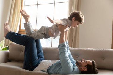Mutlu genç baba oğluyla uçakla oynuyor..