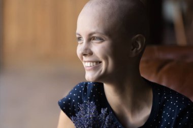 Kanserden muzdarip gülümseyen tüysüz bir kadın hayal görüyor.