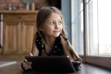 Küçük beyaz kız tablet kullanarak yerde rahatla.