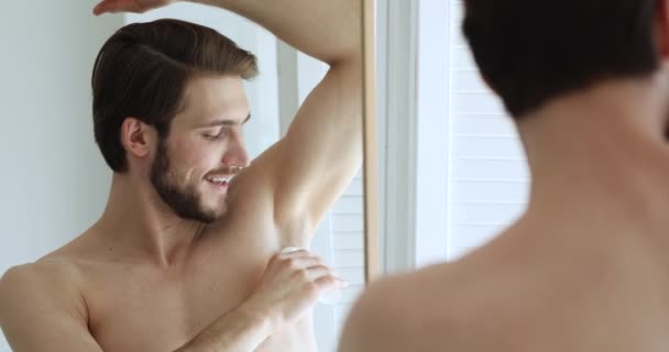 Glad ung kille som använder antiperspirant efter morgonduschen. — Stockvideo