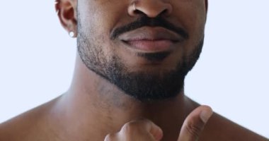 Genç Afrikalı Amerikalı adam sakala dokunuyor..