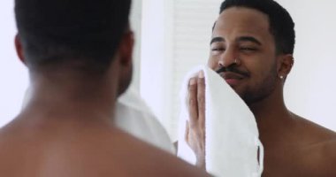 Mutlu, genç, üstsüz, etnik kökenli, yüzü havluyla silen adam..