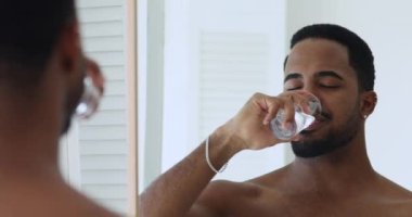 Gülümseyen melez adam saf su içiyor..