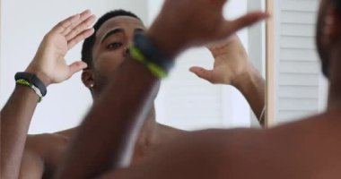 Gülümseyen, genç, melez bir adam tuvalette kendini cesaretlendiriyor..