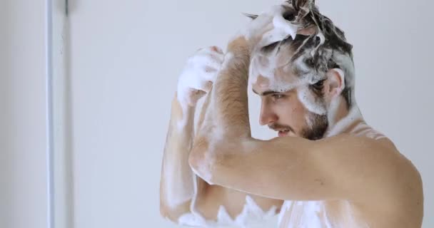 Sonriente guapo peinado chico lavado cuero cabelludo cabello en ducha. — Vídeo de stock