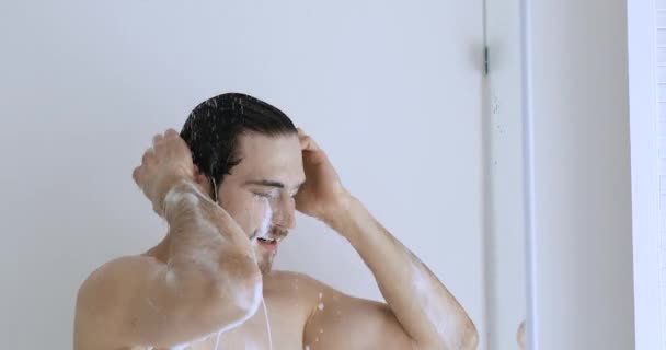 Jovem homem nu lavando fora shampoo hidratante ou gel corporal . — Vídeo de Stock