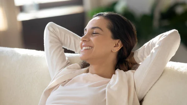 Young attractive woman relaxing on comfortable couch. — Stock Photo, Image