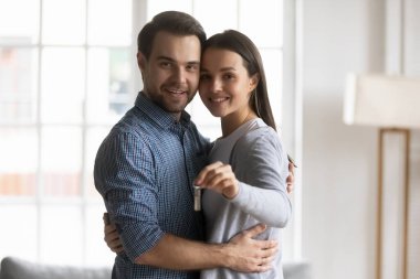 Anahtarları gösteren mutlu aile eşlerinin portresi.