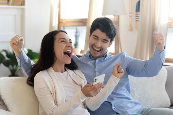 Overjoyed young family couple celebrating online lottery win. — Stock Photo, Image