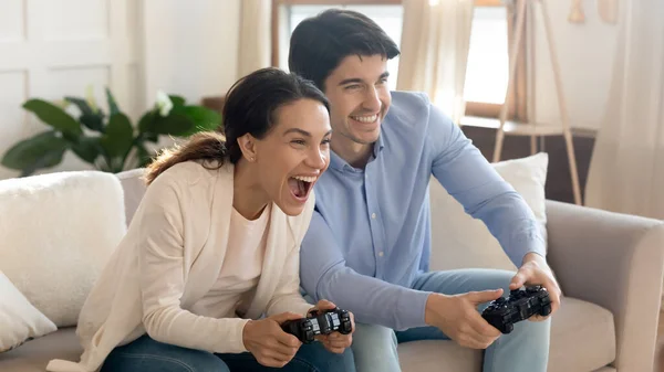Émotionnel positif jeune couple familial aimant jouer à des jeux vidéo en ligne. — Photo