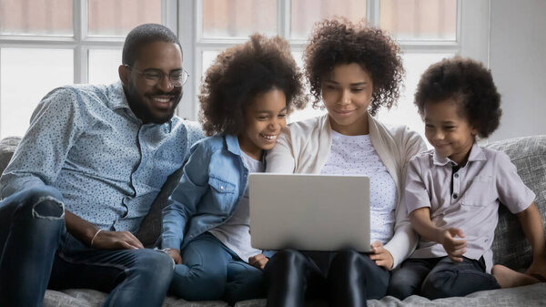 Happy biracial family with kids using laptop