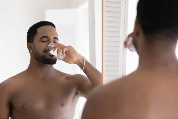 Close up mirror reflection African American man drinking pure water — Stock Photo, Image